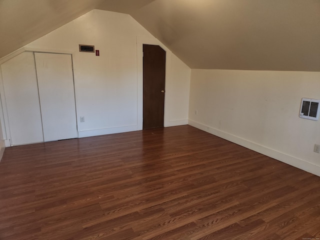 bonus room featuring dark wood-type flooring, heating unit, and lofted ceiling