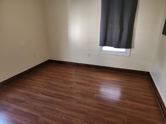 spare room featuring dark wood-type flooring