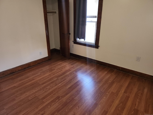 unfurnished bedroom featuring dark hardwood / wood-style flooring and a closet