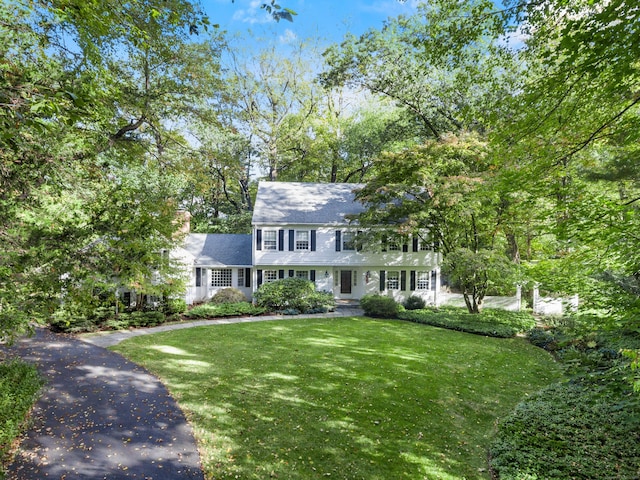 colonial inspired home featuring a front lawn