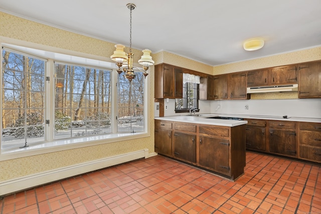 kitchen with cooktop, crown molding, hanging light fixtures, kitchen peninsula, and a baseboard heating unit