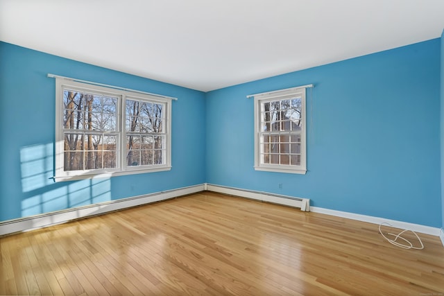 unfurnished room with a baseboard radiator and light hardwood / wood-style floors