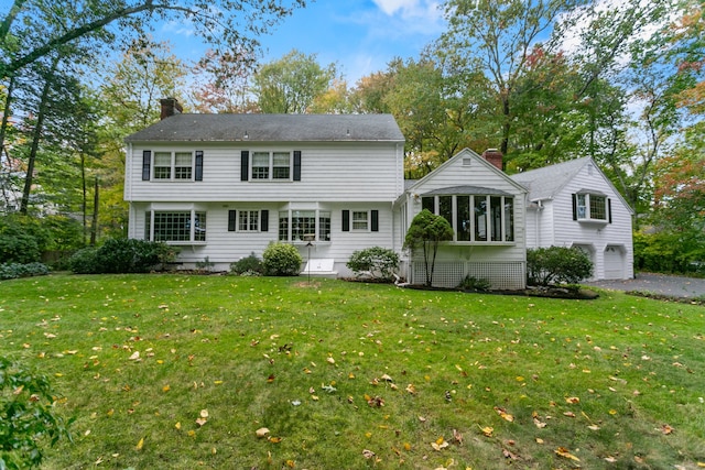 rear view of house with a garage and a yard