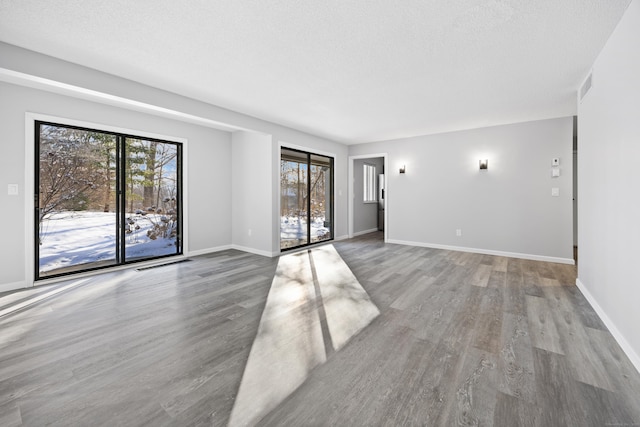 spare room with hardwood / wood-style floors and a textured ceiling