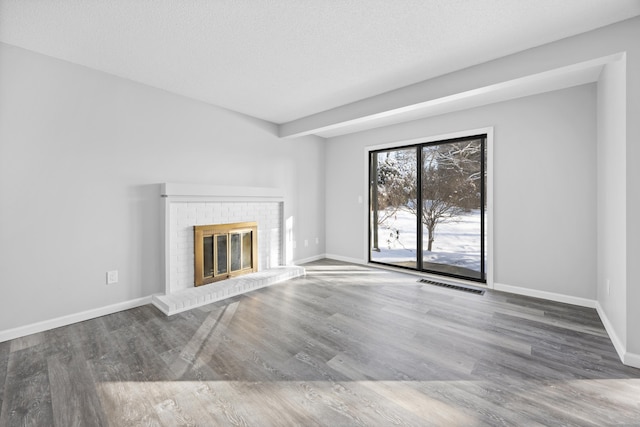 unfurnished living room with a fireplace, hardwood / wood-style floors, and a textured ceiling