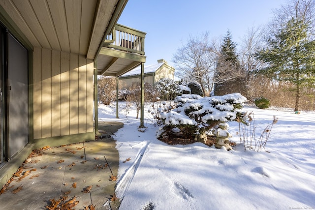 yard layered in snow featuring a balcony