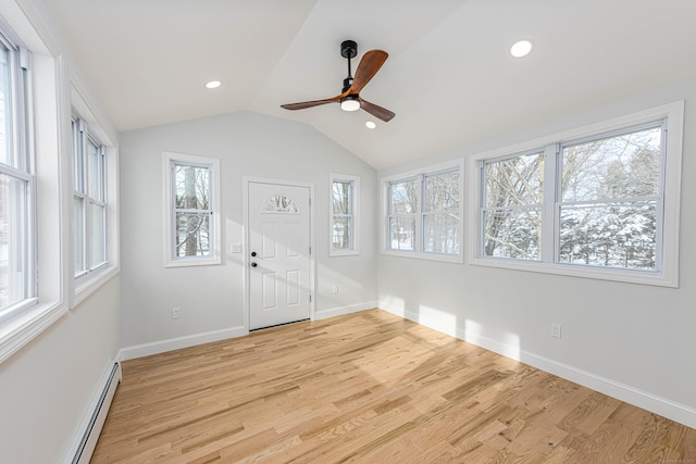 unfurnished sunroom with ceiling fan, baseboard heating, and vaulted ceiling