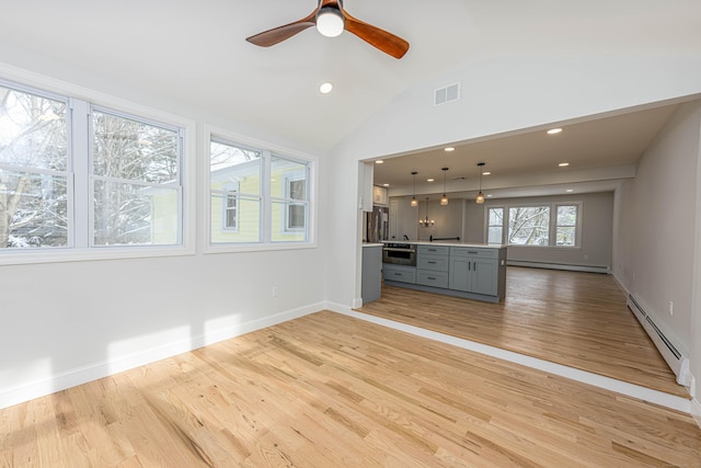 unfurnished living room featuring baseboard heating, light wood-type flooring, vaulted ceiling, and ceiling fan