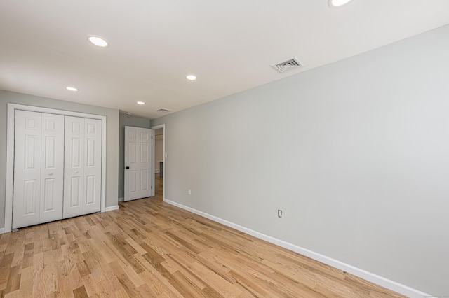 unfurnished bedroom featuring light hardwood / wood-style flooring and a closet