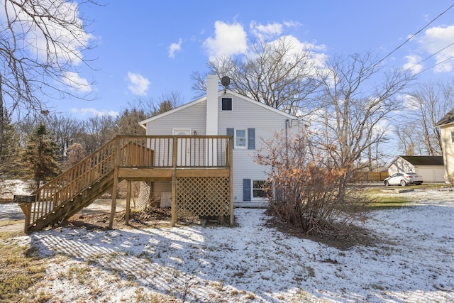 snow covered back of property featuring a deck