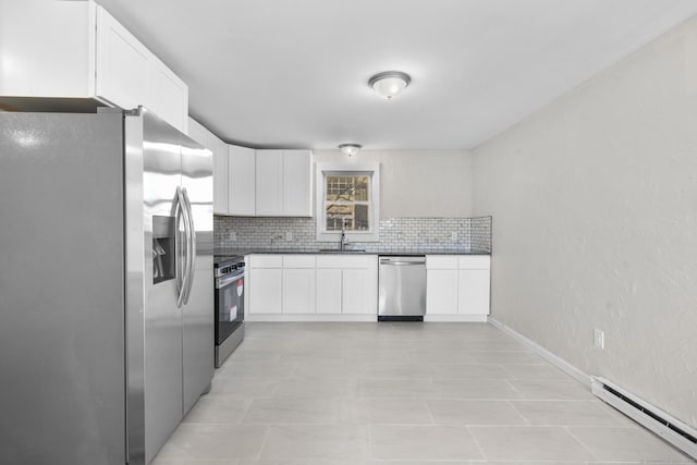 kitchen featuring appliances with stainless steel finishes, white cabinetry, a baseboard heating unit, sink, and backsplash