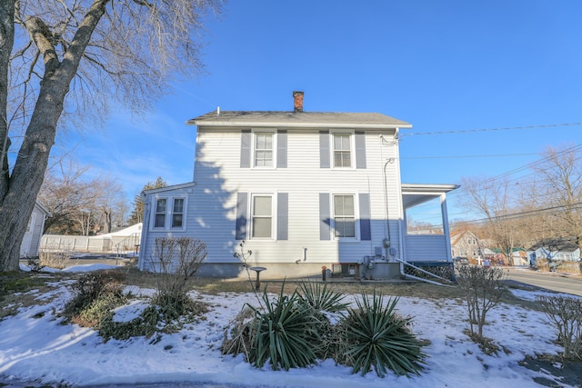 view of snow covered rear of property