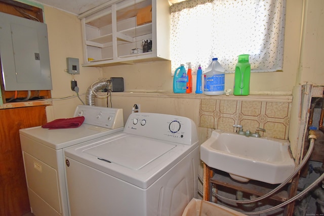 clothes washing area featuring sink, washer and clothes dryer, and electric panel