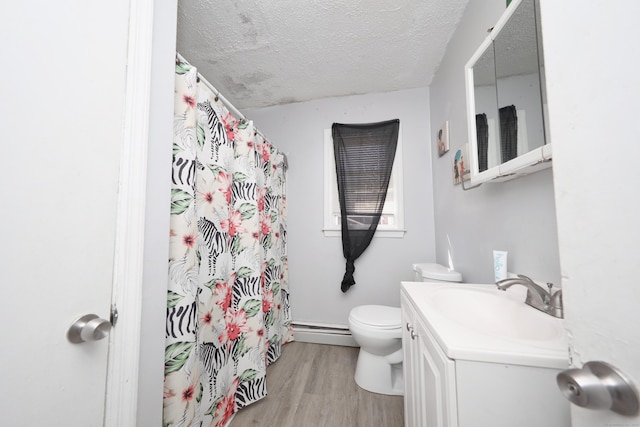 full bathroom with vanity, wood finished floors, a textured ceiling, a baseboard heating unit, and toilet