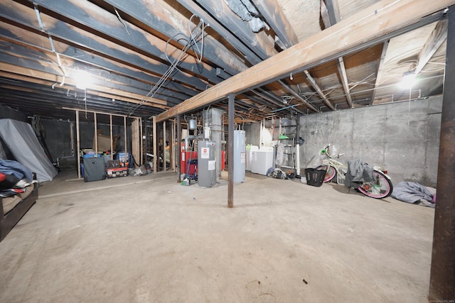 unfinished below grade area featuring electric water heater and washing machine and dryer