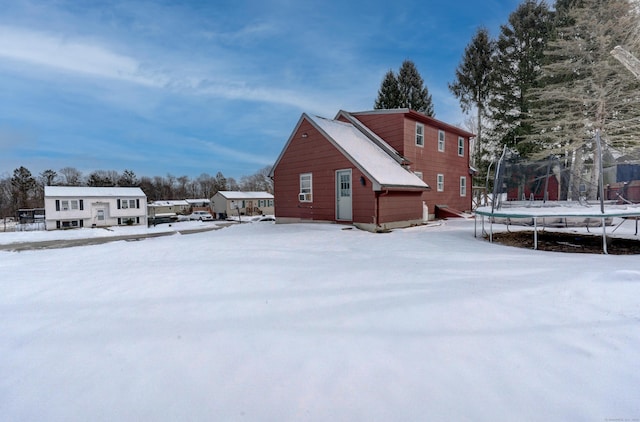 snow covered property with a trampoline