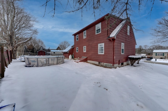 view of snow covered back of property