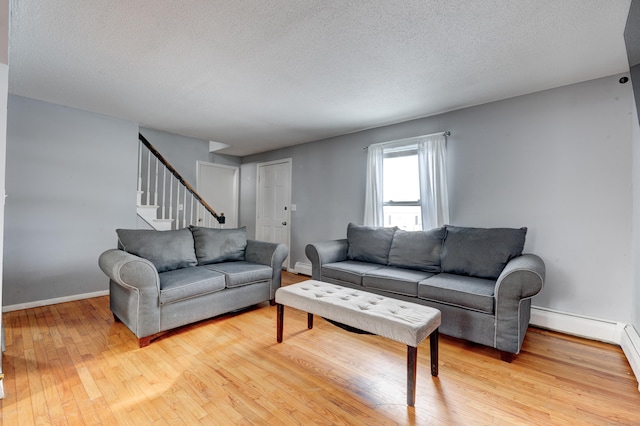 living room featuring a textured ceiling and light hardwood / wood-style flooring