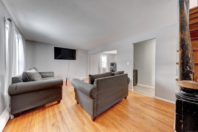 living room with wood-type flooring and a textured ceiling