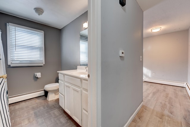 bathroom featuring vanity, baseboard heating, and toilet