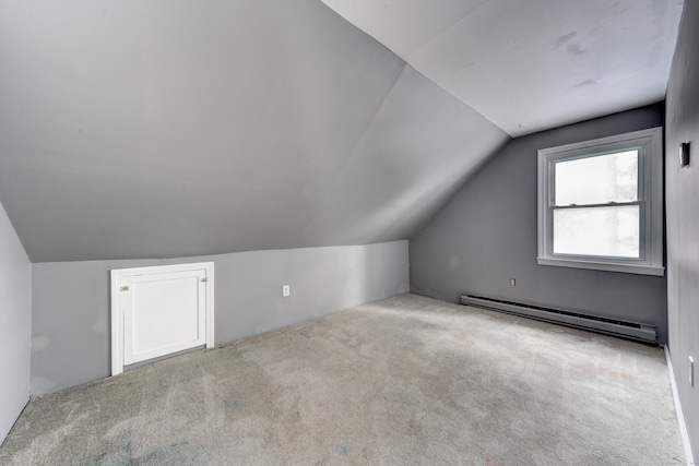 bonus room with vaulted ceiling, a baseboard radiator, and light colored carpet