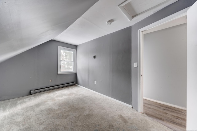 bonus room featuring lofted ceiling, a baseboard heating unit, and light carpet