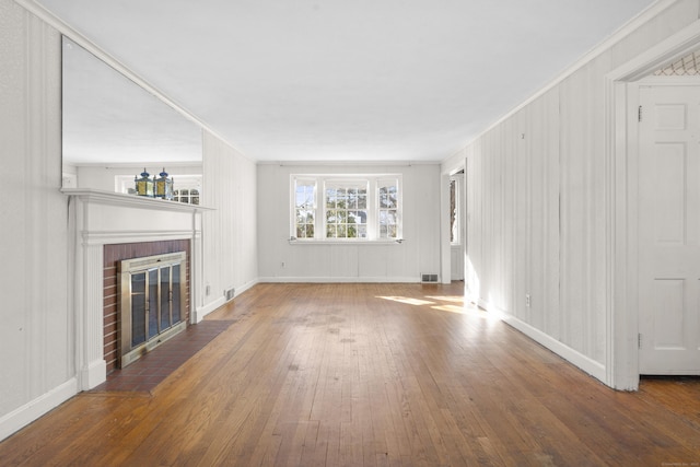 unfurnished living room with crown molding, a fireplace, and dark wood-type flooring