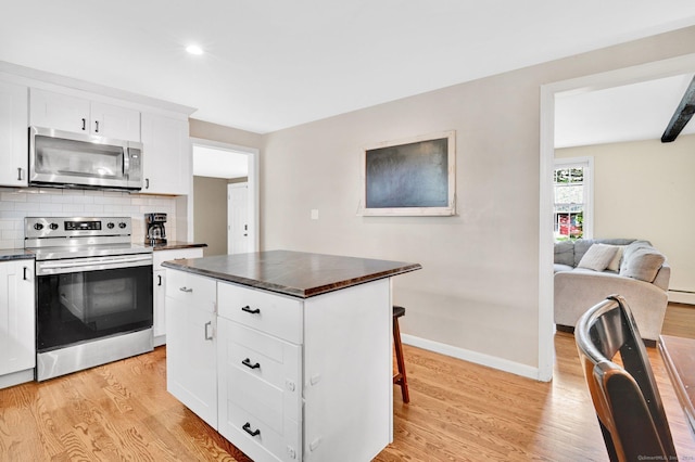 4 Sparkle St, Enfield, CT 06082 - kitchen with appliances with stainless steel finishes, dark countertops, light wood-type flooring, tasteful backsplash, and baseboards