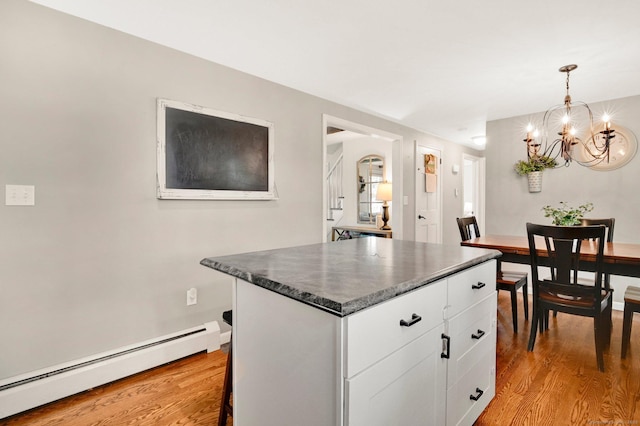 4 Sparkle St, Enfield, CT 06082 - kitchen with a baseboard radiator, a chandelier, dark countertops, and light wood-style flooring