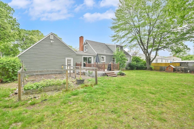 4 Sparkle St, Enfield, CT 06082 - back of house featuring a chimney, a garden, a wooden deck, and a storage unit