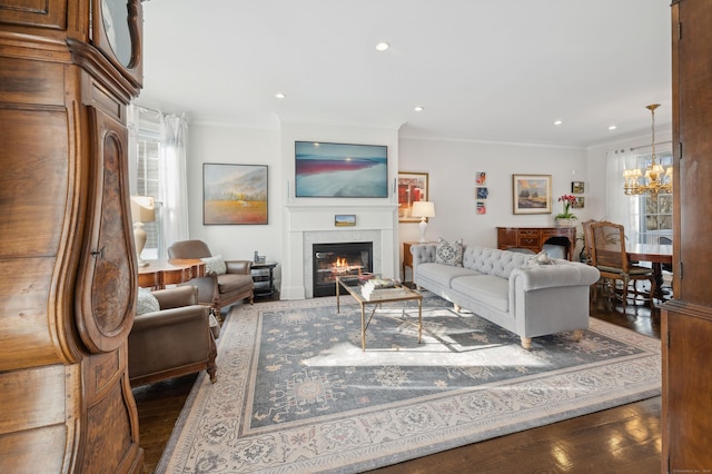 living room with ornamental molding, dark hardwood / wood-style floors, and a notable chandelier