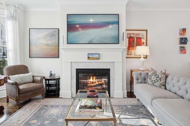 living room with hardwood / wood-style floors, a high end fireplace, and ornamental molding