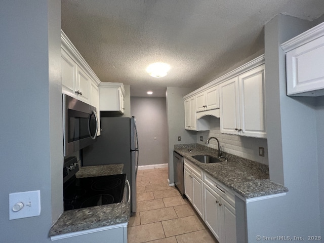 kitchen with light tile patterned floors, appliances with stainless steel finishes, sink, and white cabinets