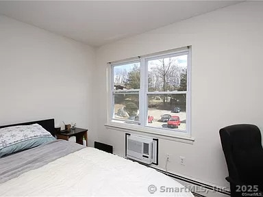 bedroom featuring a baseboard heating unit and a wall unit AC