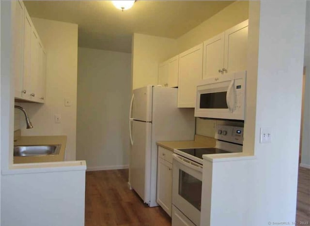 kitchen featuring dark hardwood / wood-style floors, white cabinetry, sink, and white appliances