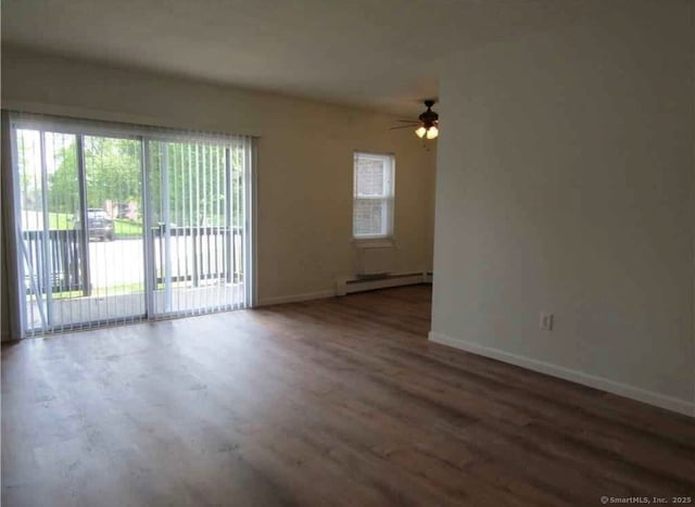 empty room featuring dark wood-type flooring, ceiling fan, and baseboard heating