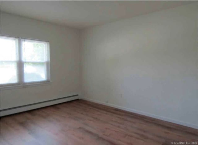 unfurnished room featuring light hardwood / wood-style flooring and baseboard heating