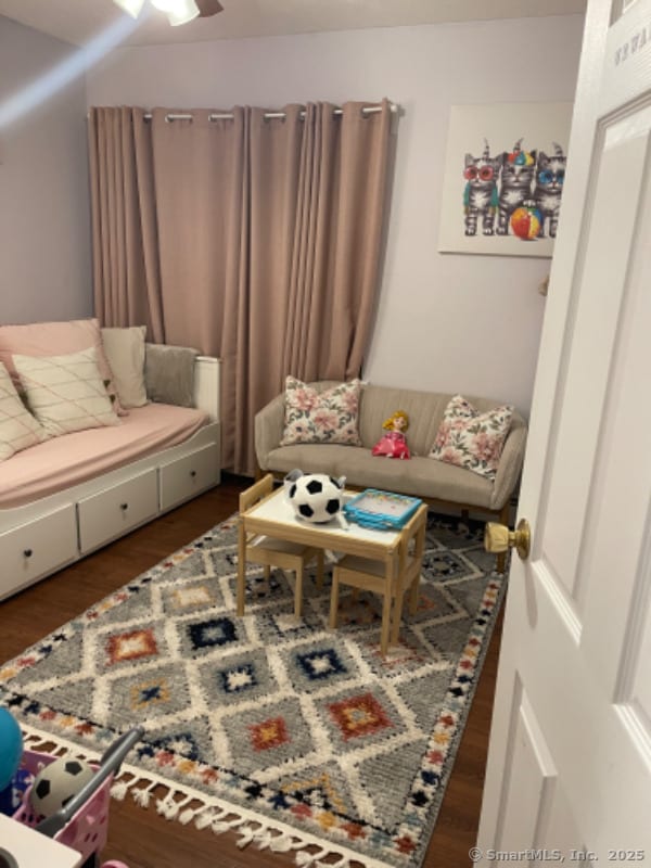 living room featuring ceiling fan and dark hardwood / wood-style flooring