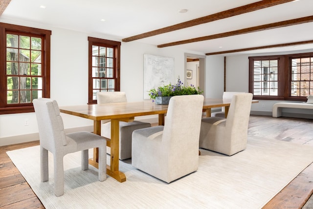 dining area featuring beamed ceiling and light wood-type flooring