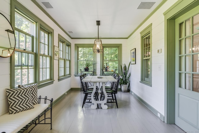 sunroom / solarium featuring an inviting chandelier