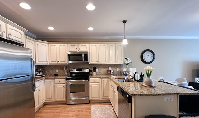 kitchen featuring appliances with stainless steel finishes, decorative light fixtures, sink, tasteful backsplash, and light stone counters