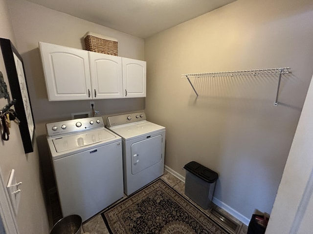 laundry area featuring cabinets, light tile patterned floors, and washing machine and clothes dryer