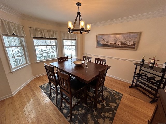 dining area featuring crown molding, a notable chandelier, and light wood-type flooring