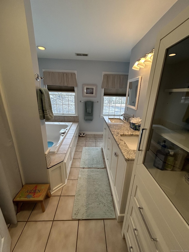 bathroom featuring vanity, a bath, and tile patterned floors