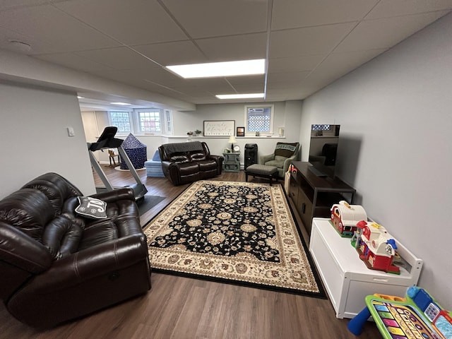 living room with wood-type flooring and a drop ceiling