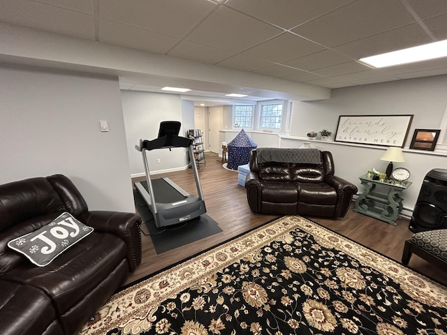 living room featuring wood-type flooring and a paneled ceiling