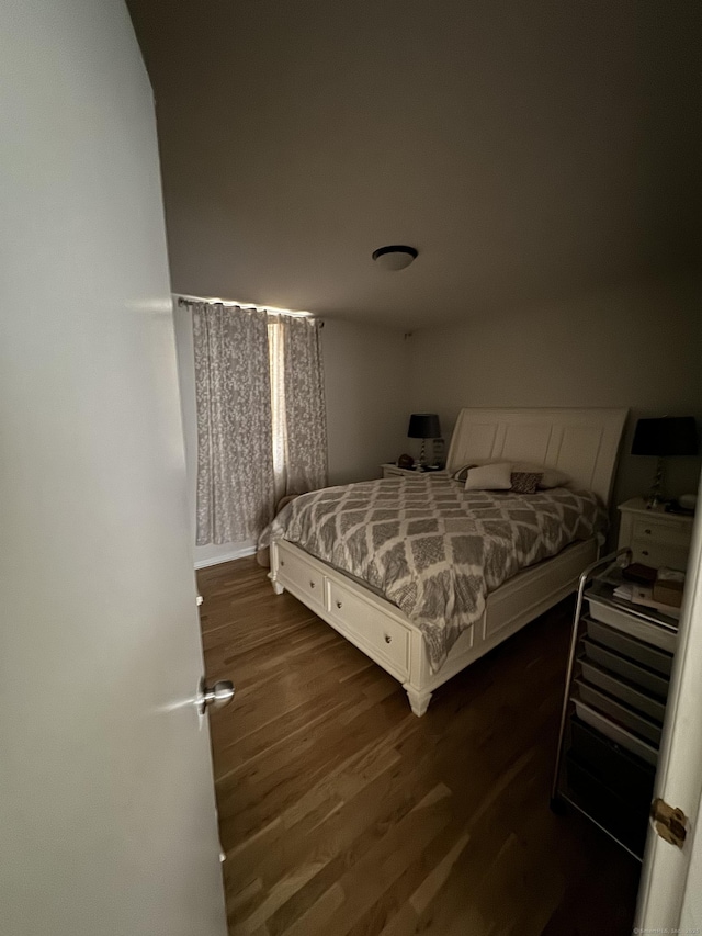 bedroom with dark wood-type flooring