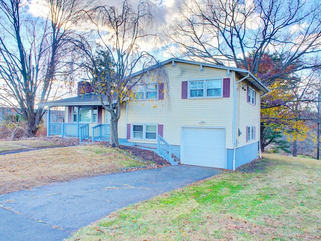 view of front of home with a garage, a front lawn, and covered porch