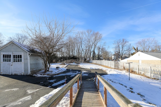 yard covered in snow with a garage and an outdoor structure