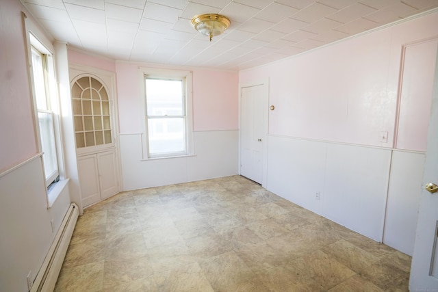 empty room featuring baseboard heating and a wealth of natural light